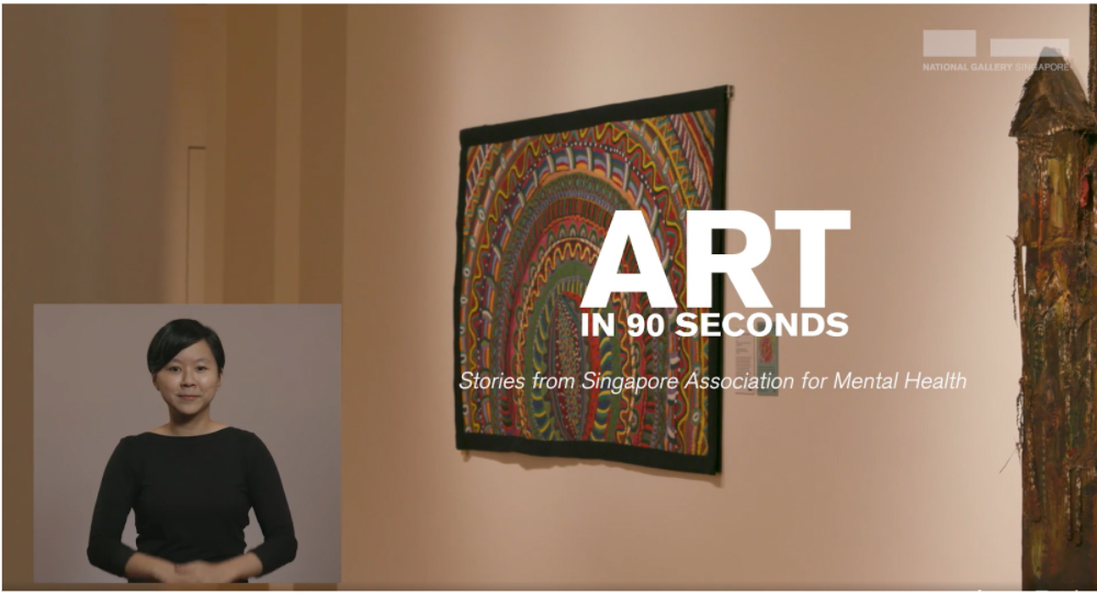 ID: Screenshot of a recorded video that shows a small window at the bottom left: Deaf interpreter in black shirt, within the main media showing the background of National Gallery. Title text on it reads: "Art in 90 seconds. Stories from Singapore Association for Mental Health".