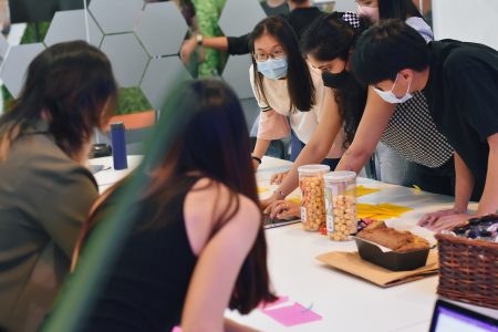 Interpreters in 2 different teams (Yellow and Pink) discussing among themselves putting all post-its together